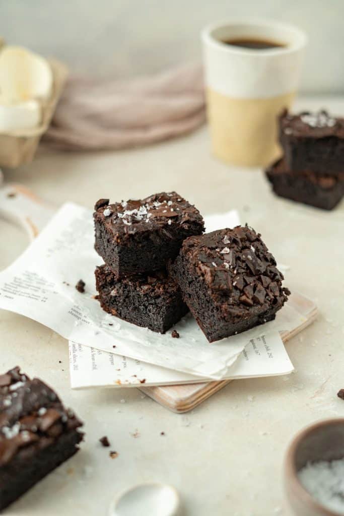 Keto Avocado Brownies Three fudgy brownies next to a steaming cup of coffee