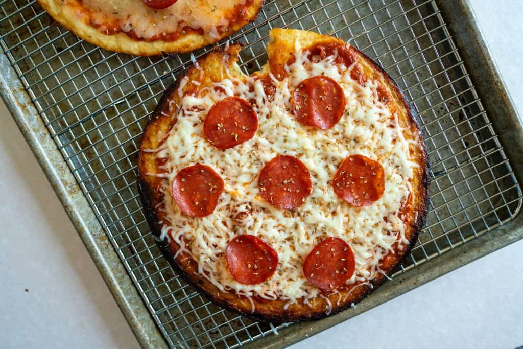 cauliflour foods cheese and pepperoni pizza fresh out of the oven on a baking sheet