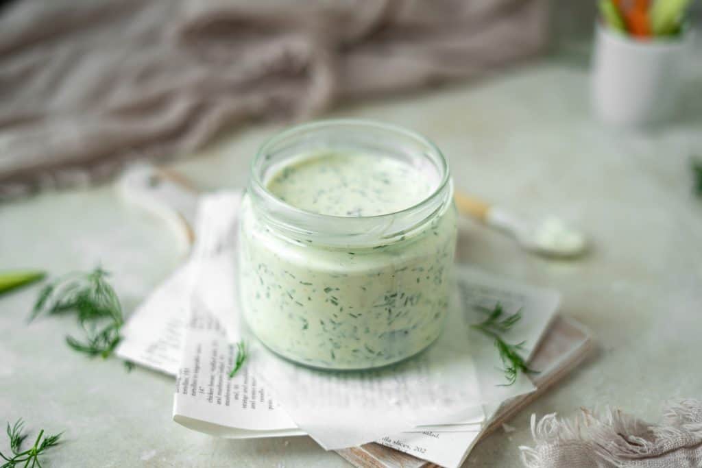 Herbs surrounding a jar of freshly made ranch