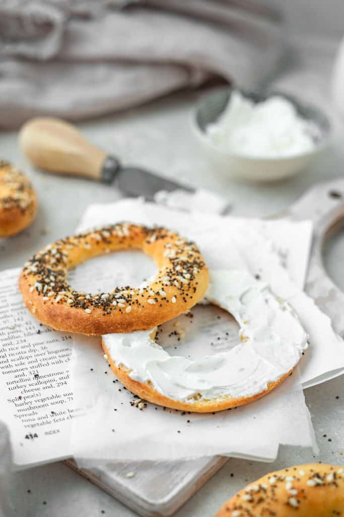 keto bagels cream cheese on a keto bagel with some extra cream cheese in the background