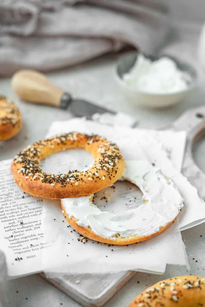 cream cheese on a keto bagel with some extra cream cheese in the background