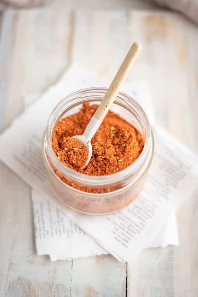 Keto taco seasoning A jar of taco seasoning with a mini spoon