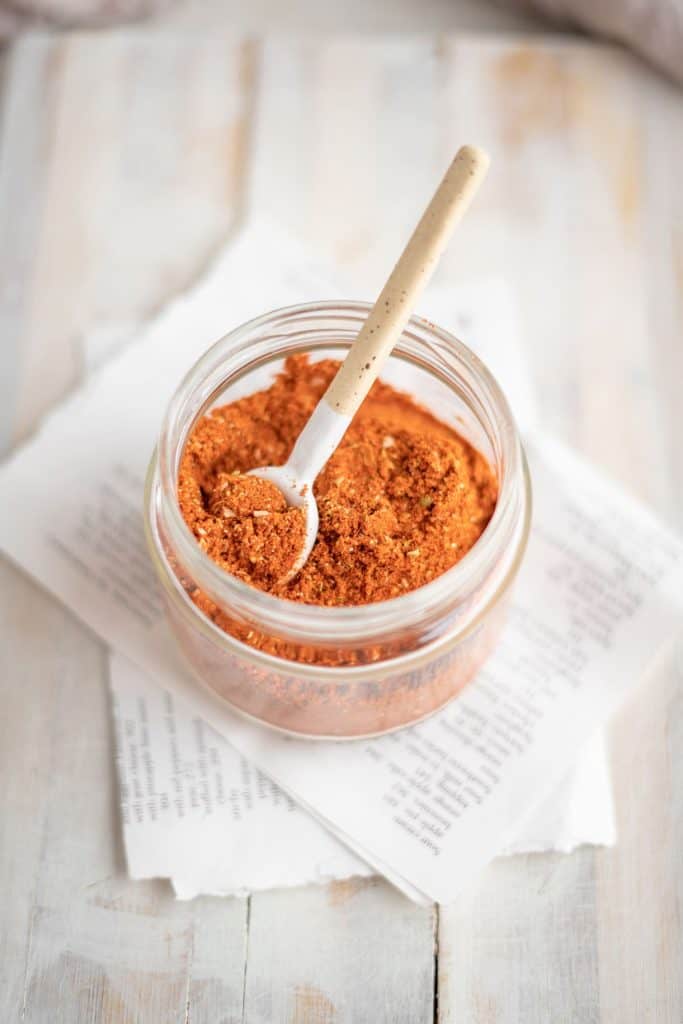 A jar of taco seasoning with a mini spoon