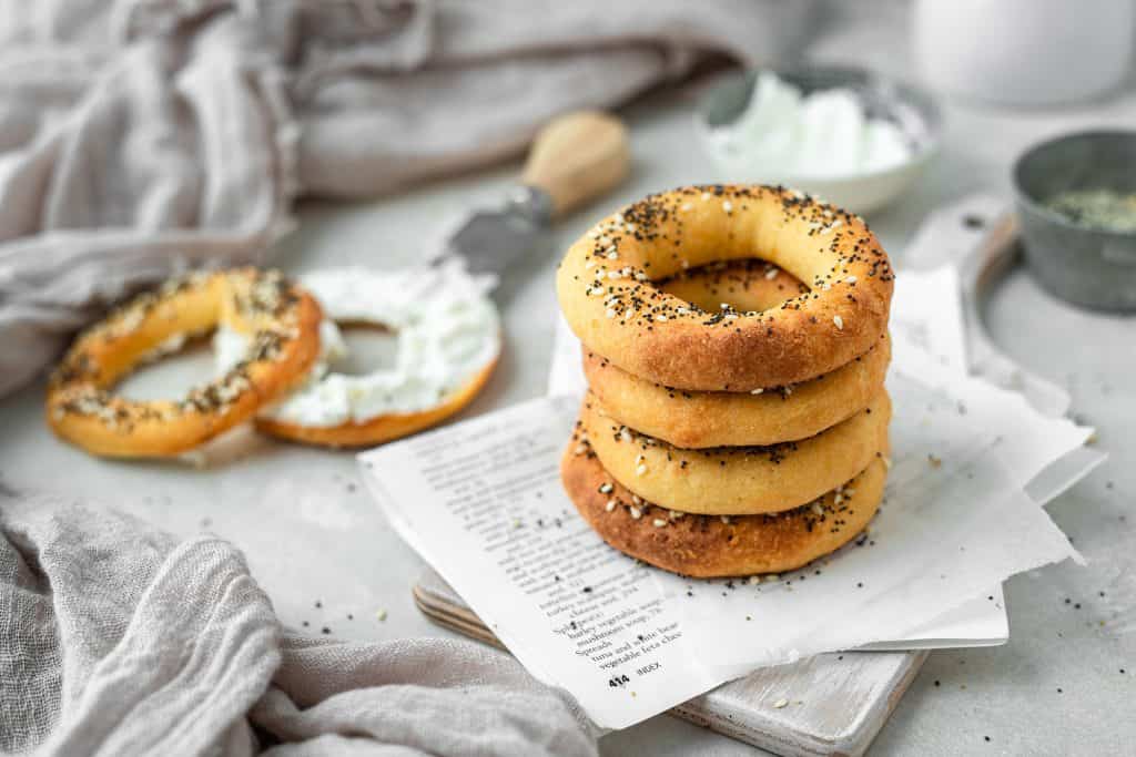 keto bagels a stack of four keto bagels on a cutting board with cream cheese in the background