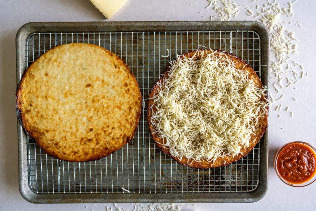 cauliflour foods two crusts on a baking tray one with cheese