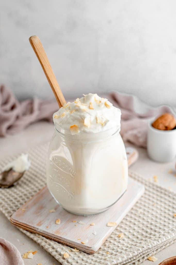 A mini cutting board with a jar of keto coconut yogurt