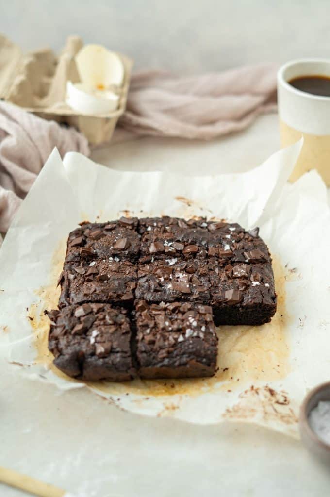 Keto Avocado Brownies Parchment paper with baked a sliced avocado brownies
