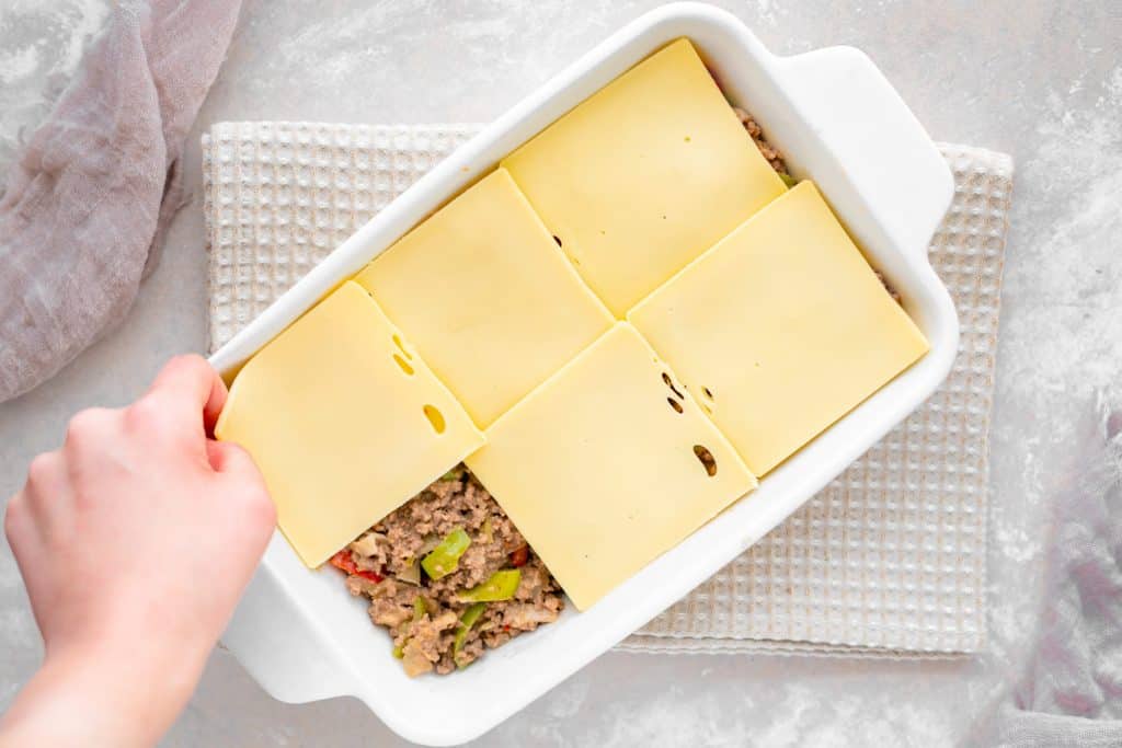 Placing cheese slices on the casserole