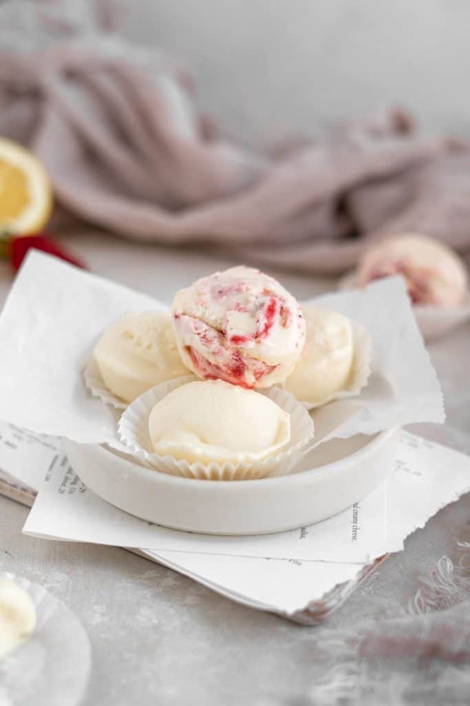 A vertical image of cheesecake fat bombs