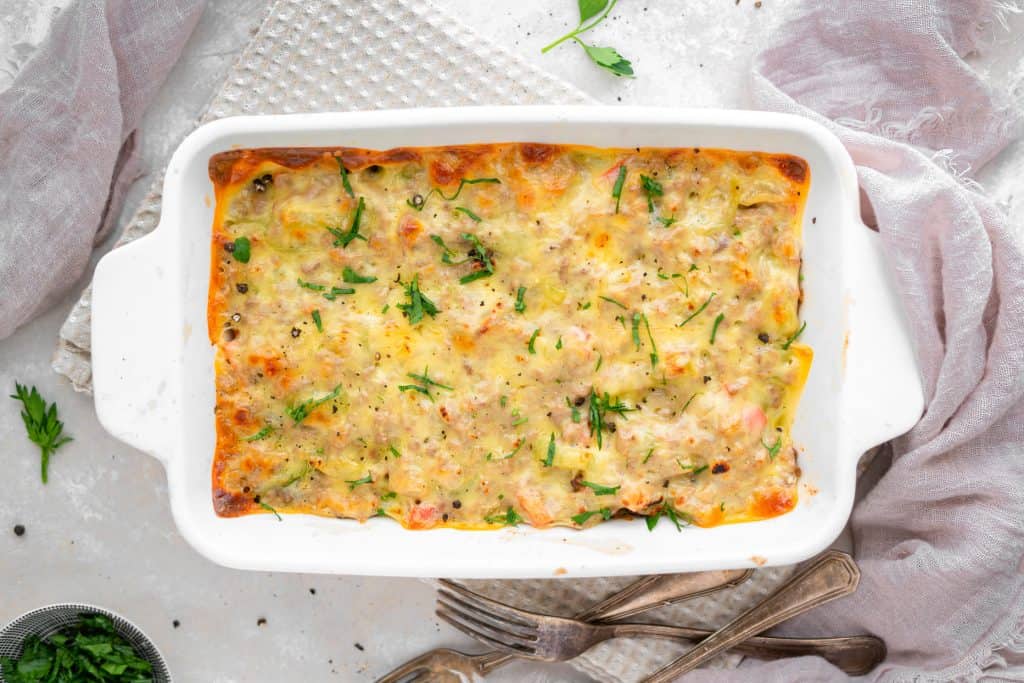Philly cheesesteak casserole A white baking dish with melted provolone on casserole