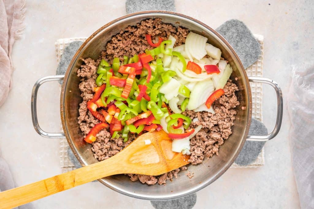 Adding the peppers and onions into philly cheesesteak casserole