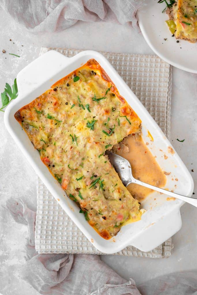 Philly cheesesteak casserole A sliver spoon scooping out freshly made casserole