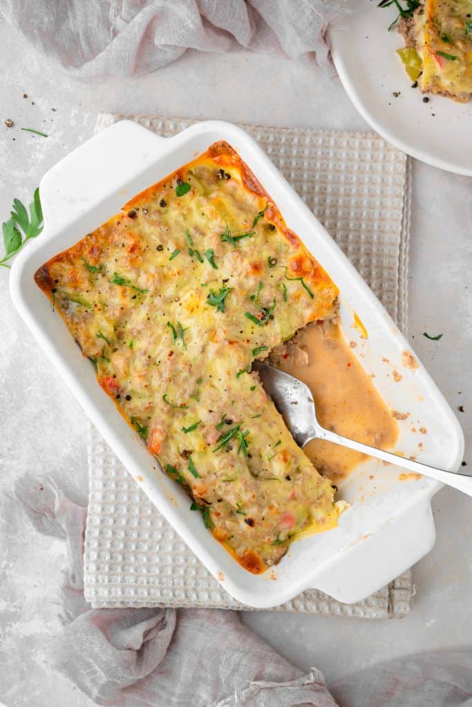 A sliver spoon scooping out freshly made casserole