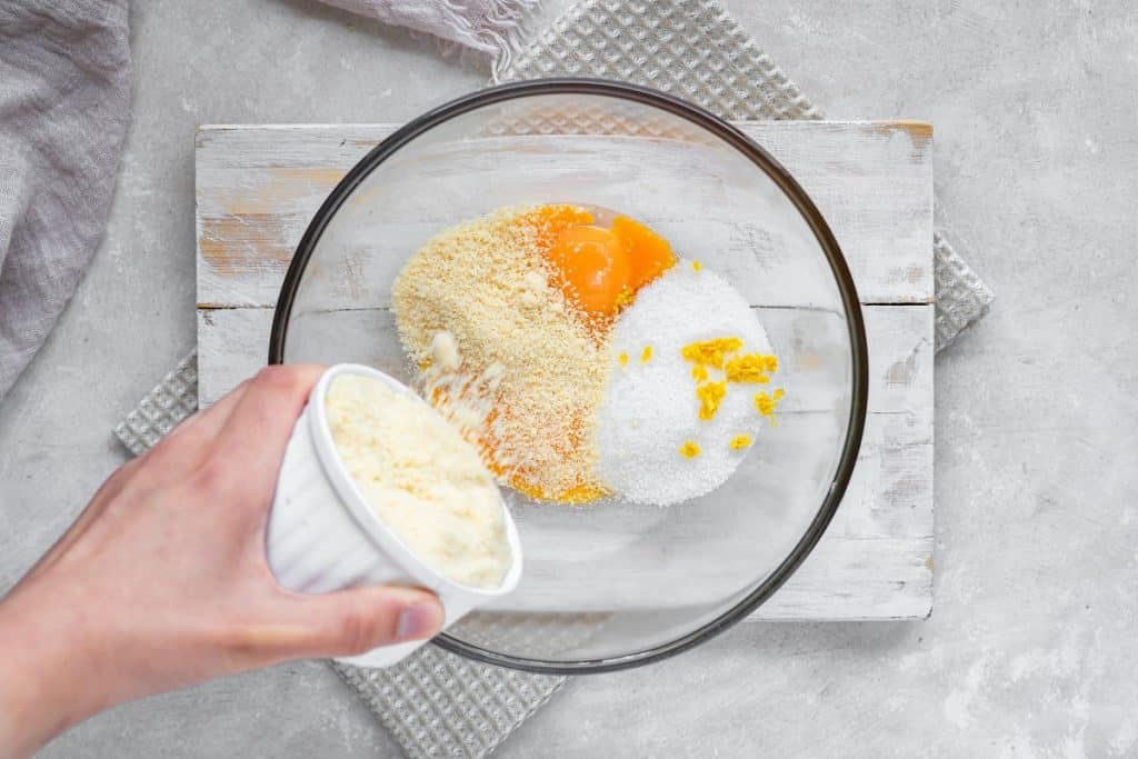 Overhead shot of the dry ingredients being added to the egg yolks.