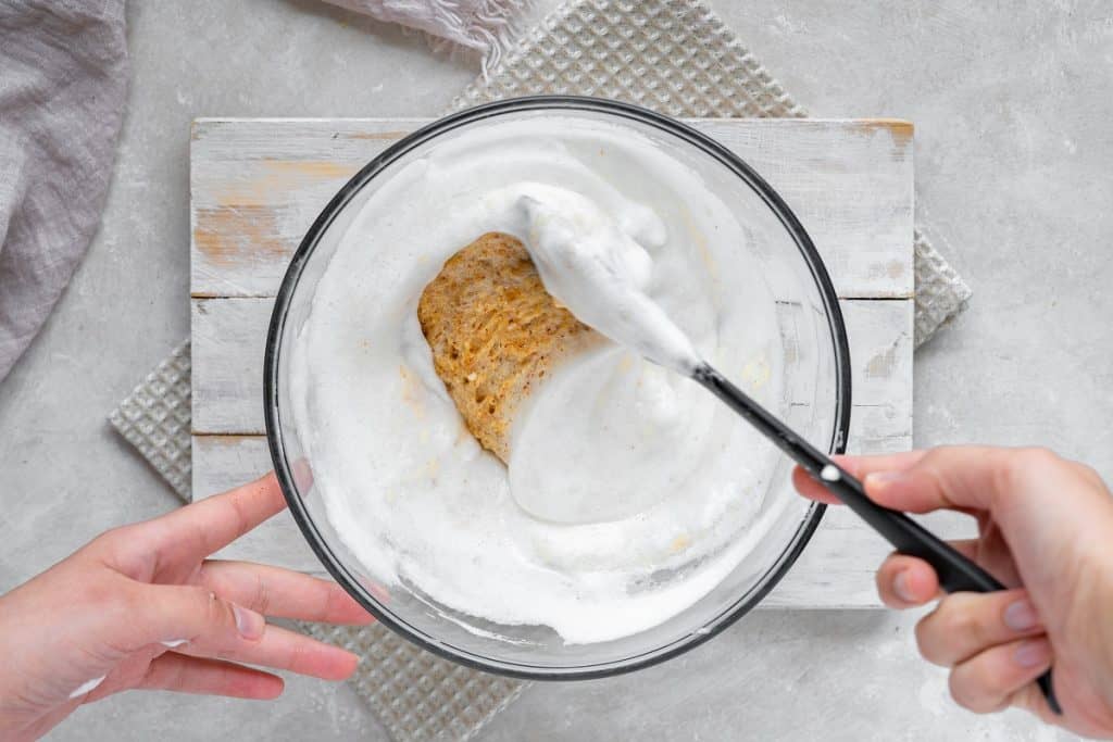 An overhead shot of the almond cake batter being folded in with the egg whites