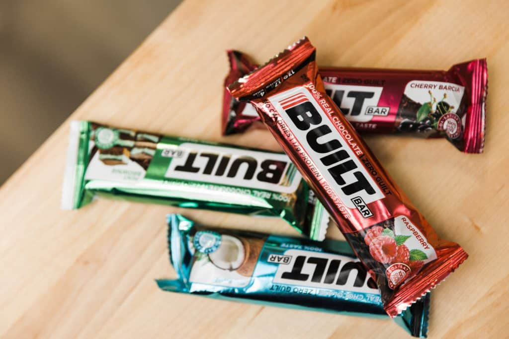 Built Bar Reviews pile of different flavor built bars on a wood table