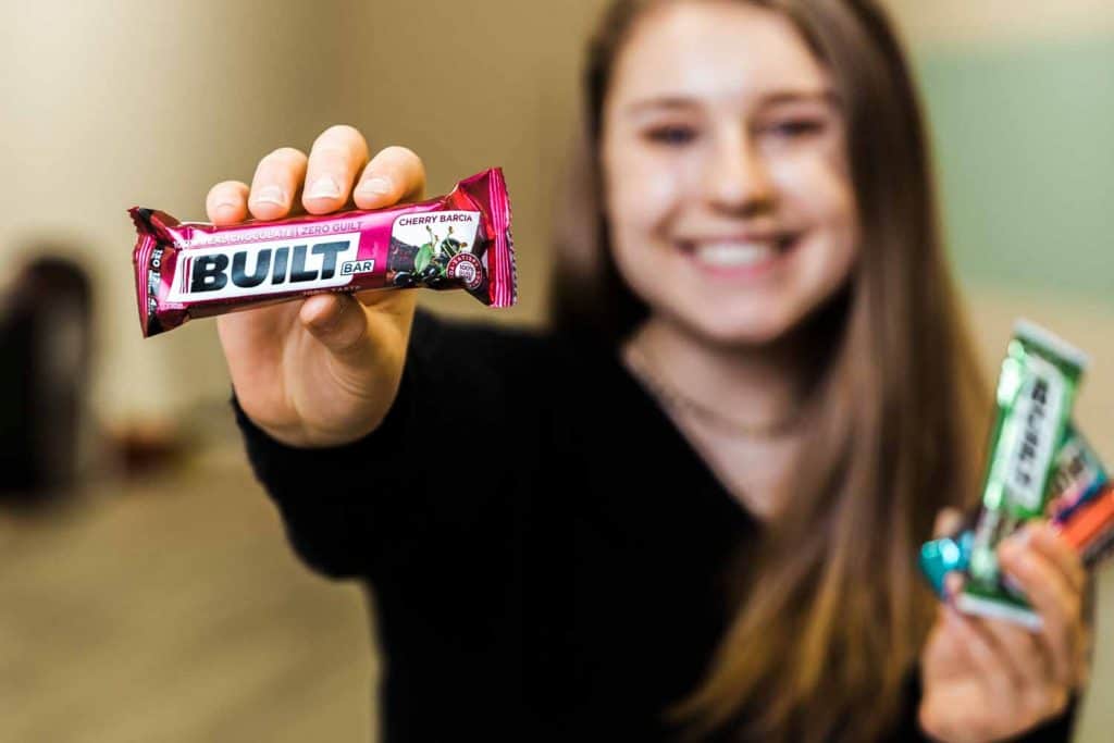 Built Bar Reviews woman holding a built bar in one hand