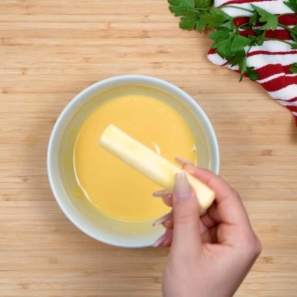 keto mozzarella sticks first we dip a string cheese into the egg wash mixture