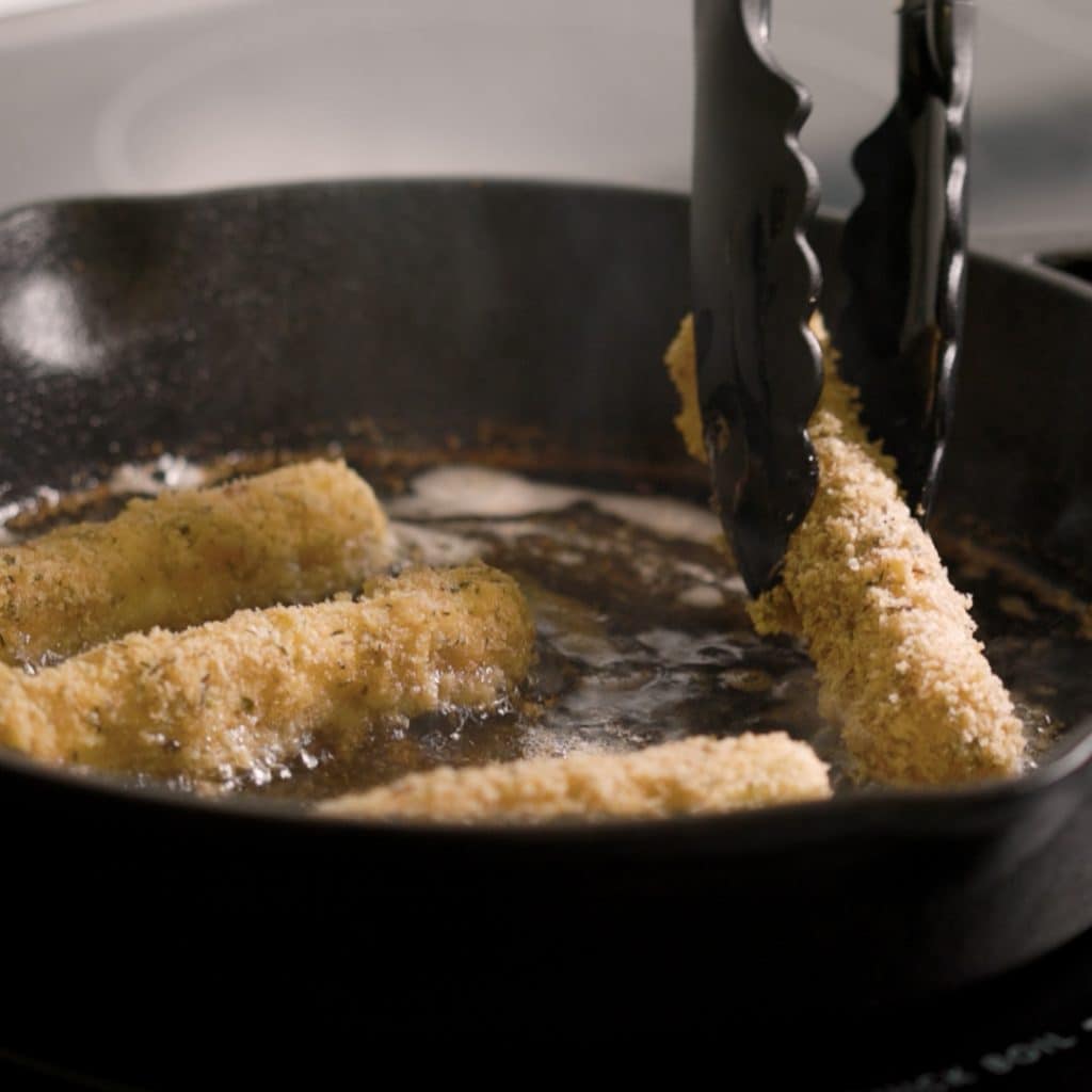 Fry the mozzarella sticks in a cast iron skillet