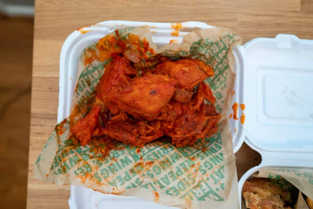 original hot wings in a cardboard takeout box