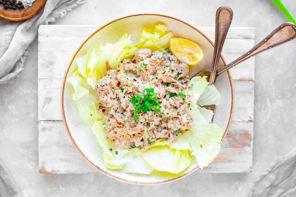 Keto Tuna Salad Tuna salad in a bowl over top lettuce leaves and spoon sticking out.