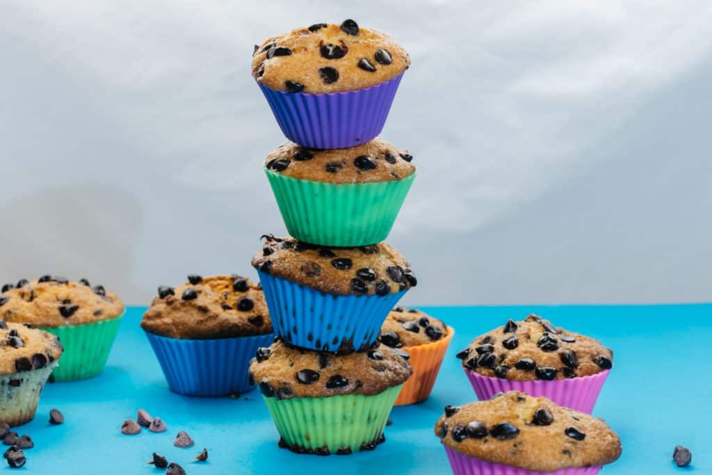 keto chocolate chip muffins Four keto muffins stacked in a tower surrounded by other muffins.