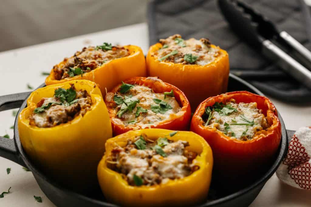 keto stuffed peppers A variety of stuffed bell peppers filling a cast iron pan