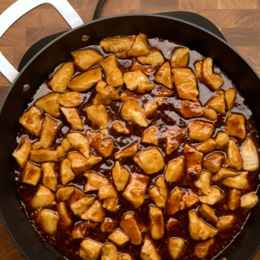 An overhead shot of chicken in teriyaki sauce cooking in a pan