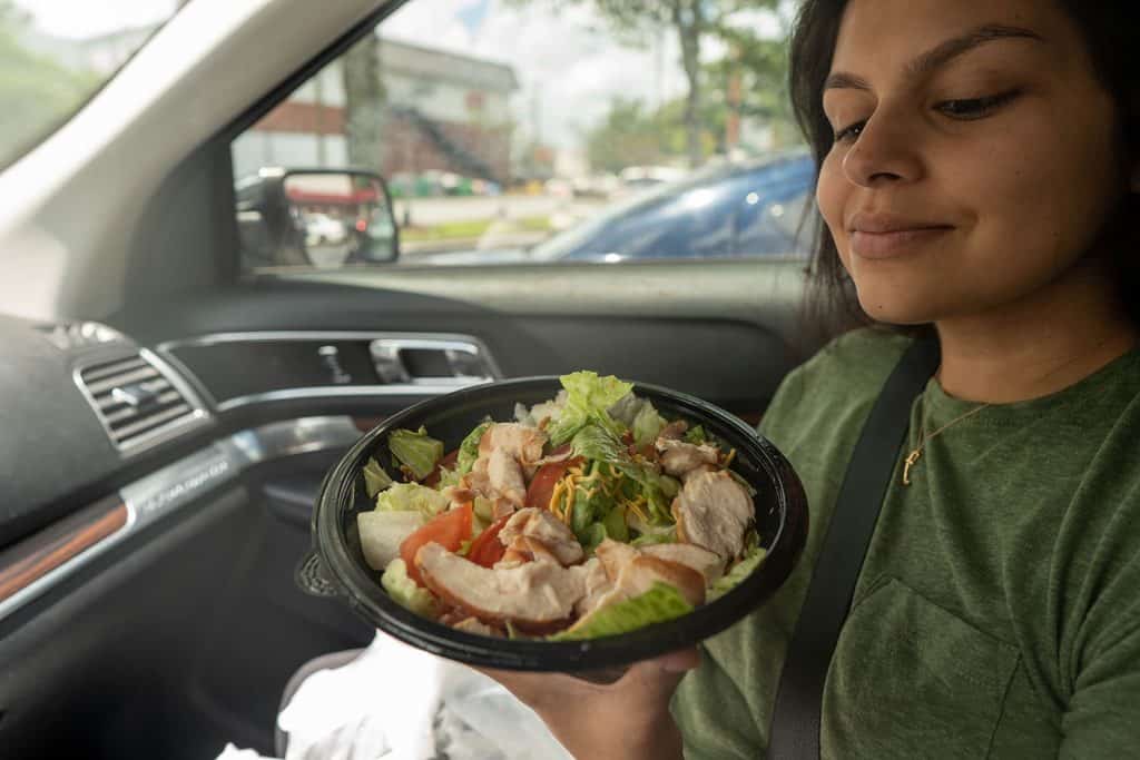 Arbys roast chicken salad in a bowl held by Megha