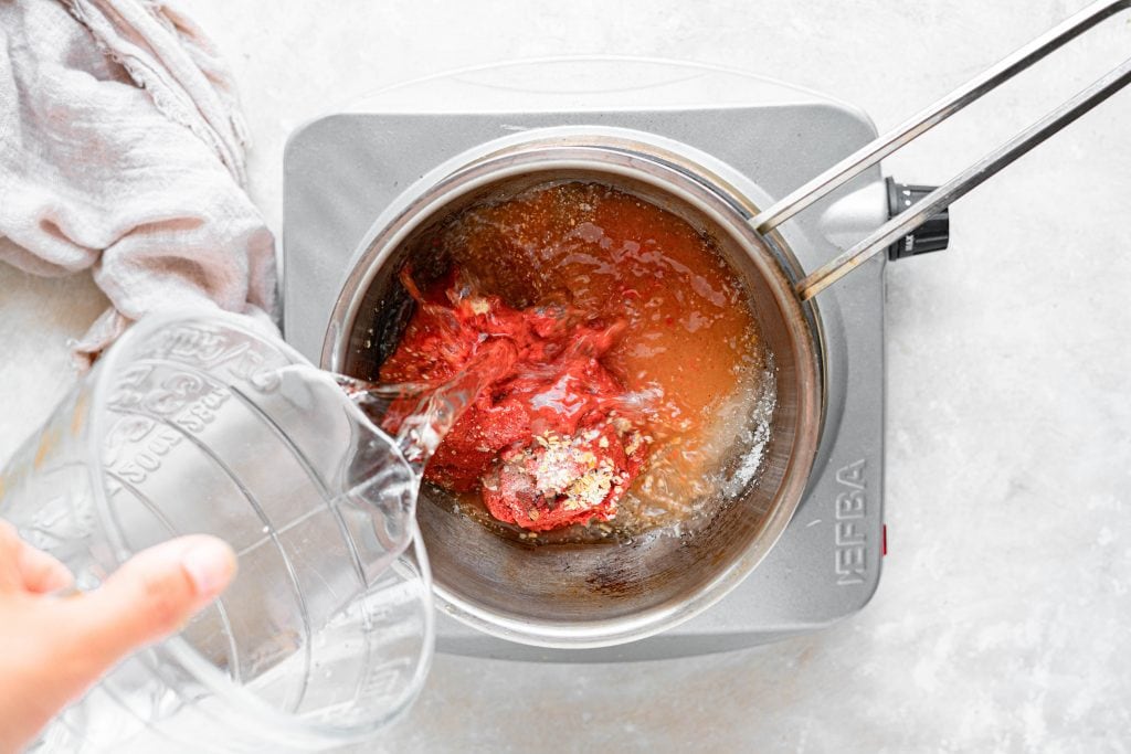 adding all ingredients for keto ketchup to a saucepan