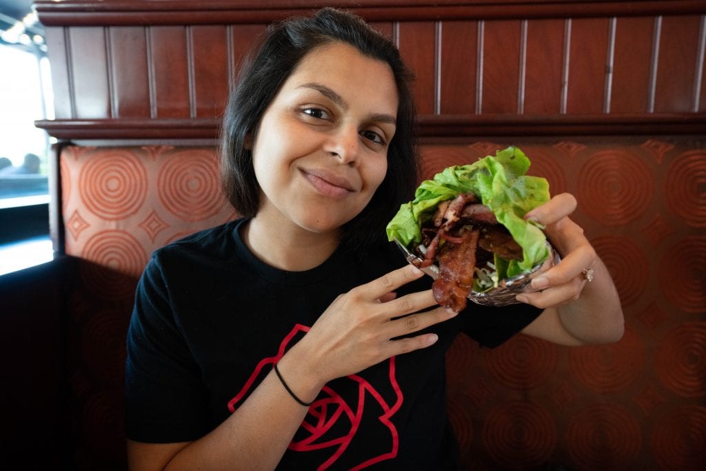 woman eating a bunless hamburger at the cheesecake factory