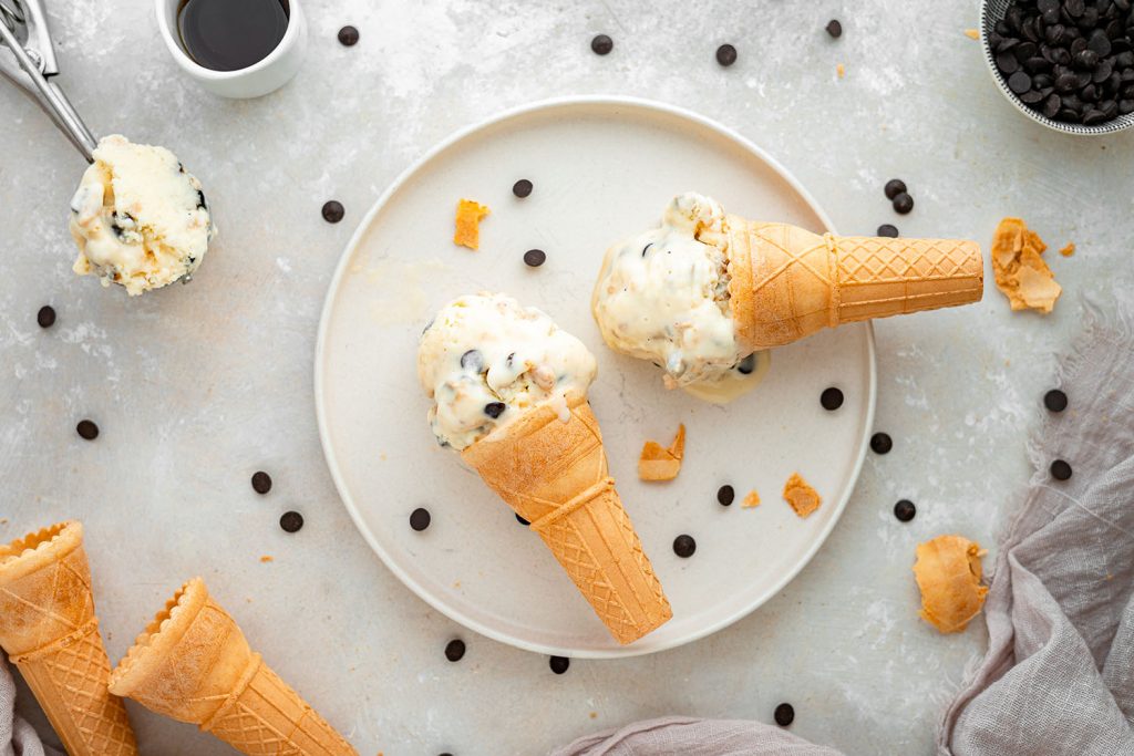 two ice cream cones on a plate with chocolate chips