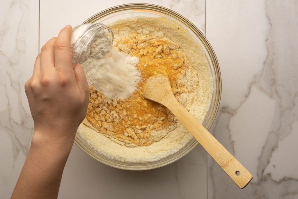 keto pumpkin muffins adding the dry ingredients to the bowl