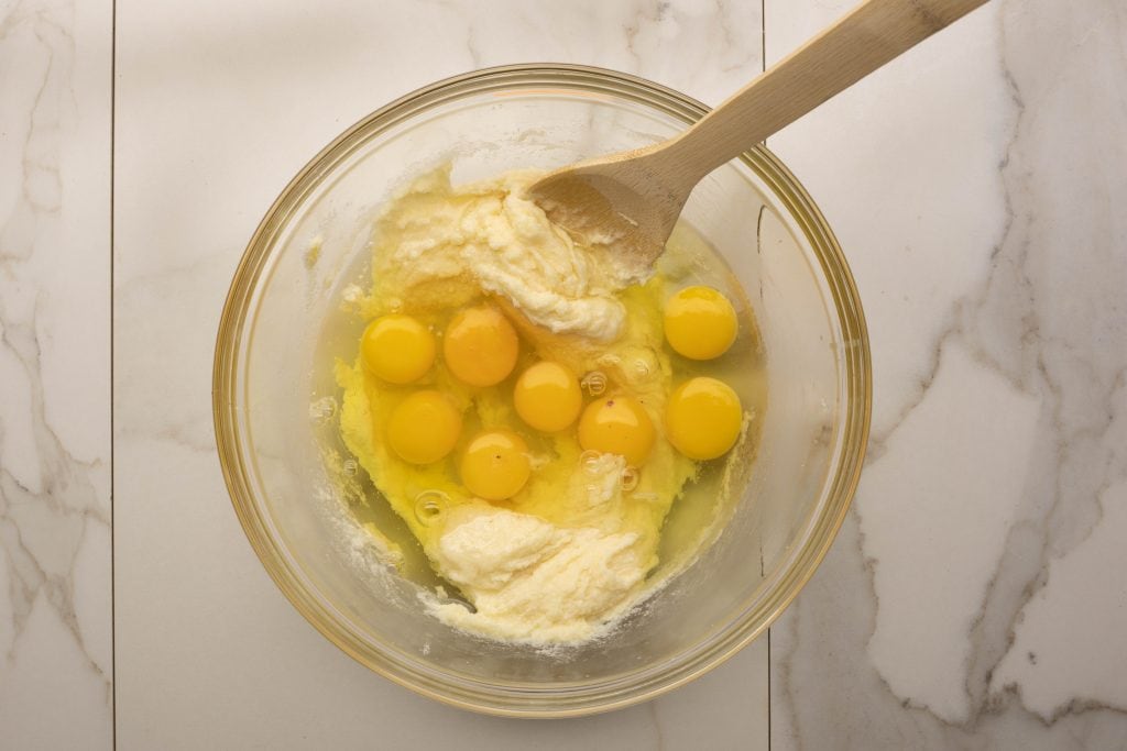 adding eggs to the mixing bowl