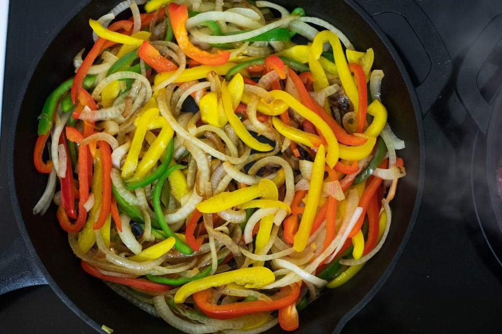 keto fajitas cooking down peppers and onions for a tender fajita base