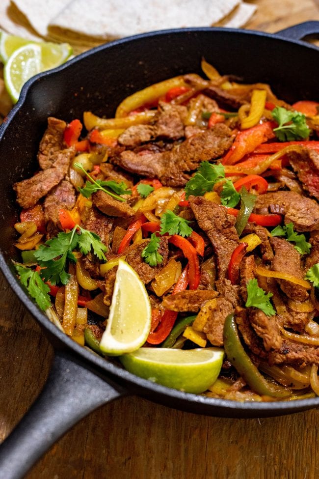 keto fajtas in a cast iron skillet with lime