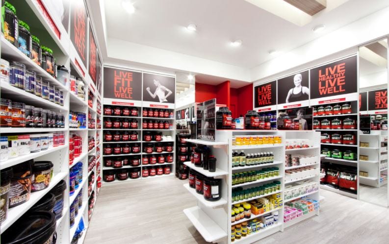 lighted gnc store with shelves of supplements