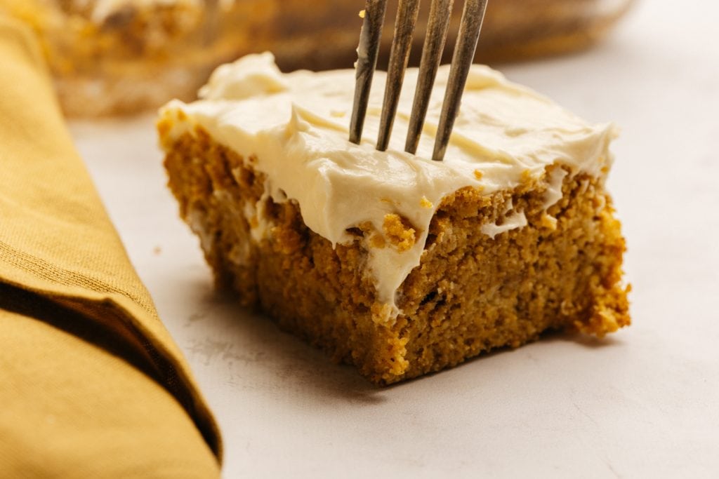 close up of a single pumpkin bar with cream cheese frosting