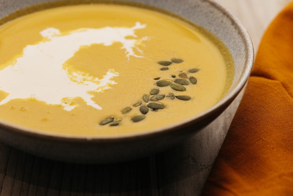 pumpkin seeds on top of a bowl of soup