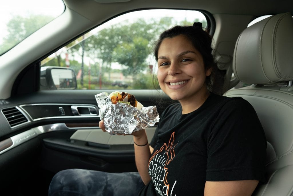 woman holding a burger without a bun from five men