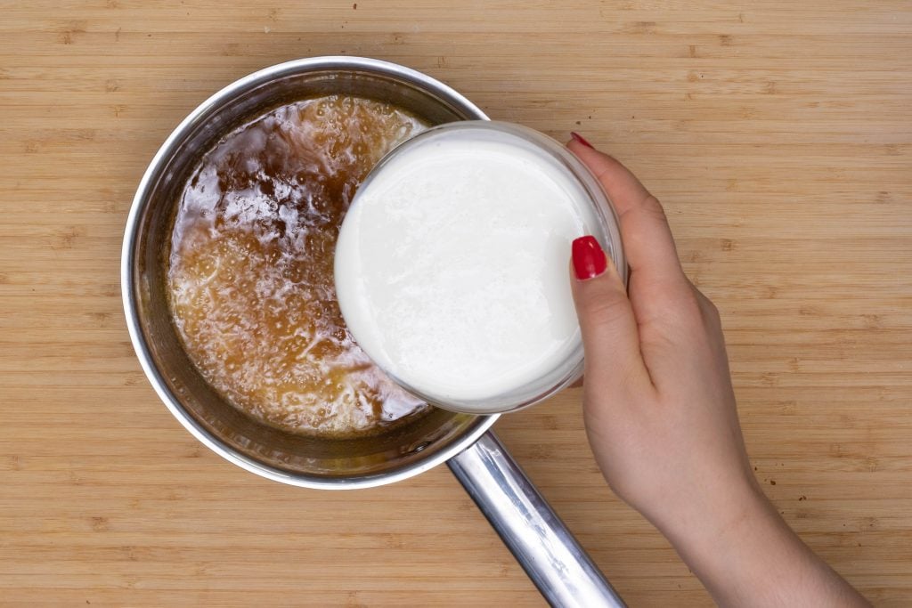 keto pecan pie cream being added to pecan pie filling