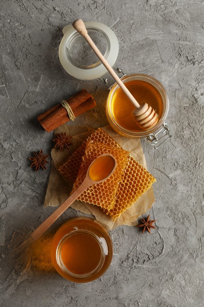 Honey in jars on a table with cinnamon and start anise 