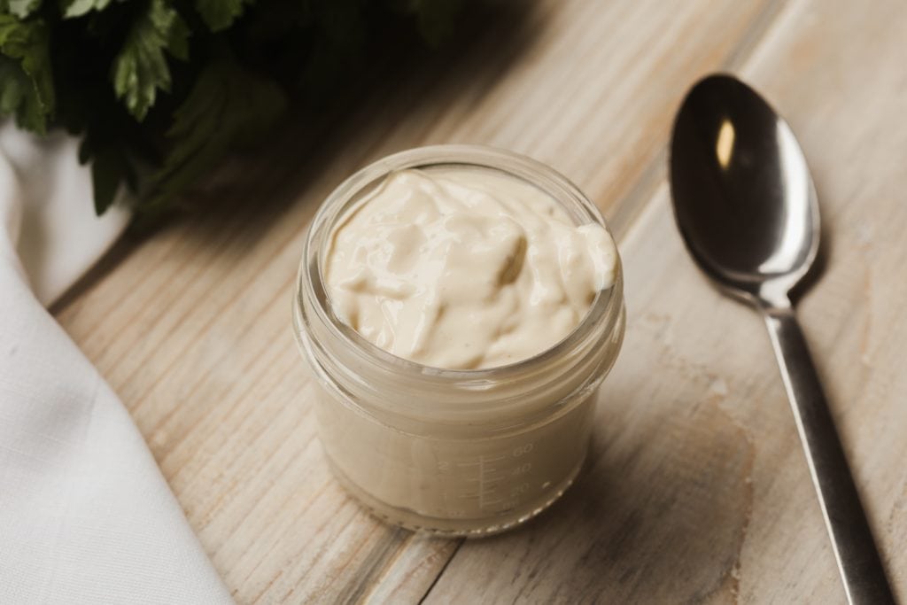 blue cheese dressing with a spoon on a cutting board