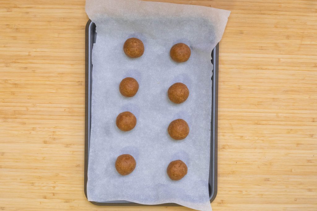 formed peanut butter balls on the parchment paper