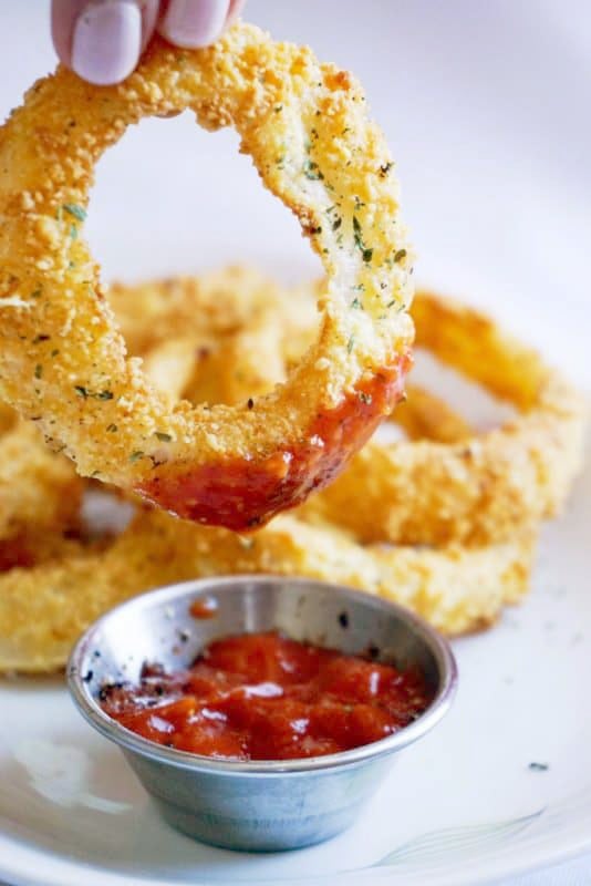 onion rings dipped in ketchup