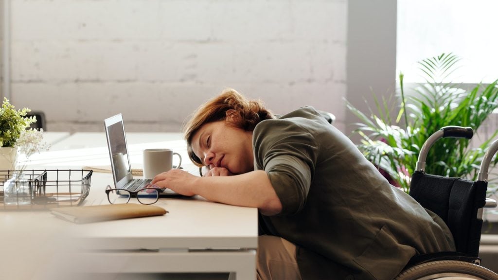 exausted woman at the office desk at work