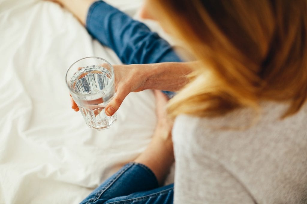 young woman holding a glass of water