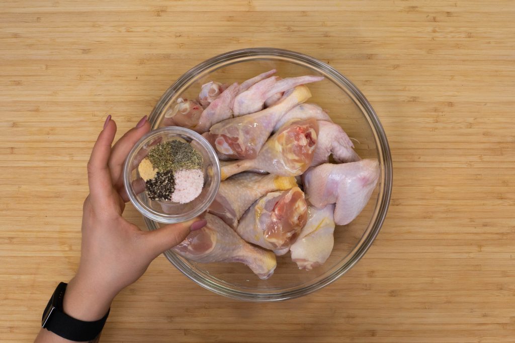 Adding spices to chicken wings