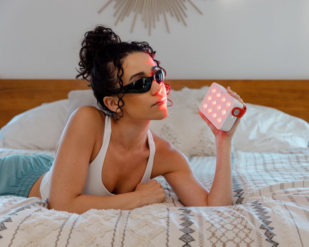 girl holding red light therapy device