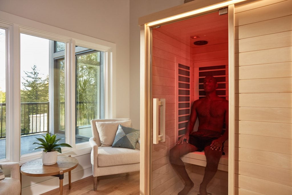 man sitting at infrared sauna at home